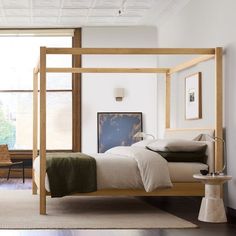 a bedroom with a four poster bed and white walls