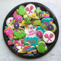 a black plate filled with decorated cookies on top of a table