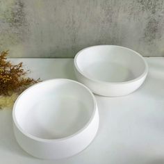 two white bowls sitting next to each other