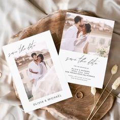 two save the dates cards sitting on top of a wooden slice