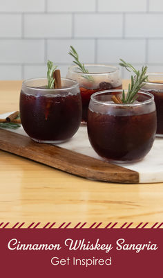 three glasses filled with cinnamon whiskey sangria sitting on a cutting board