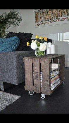 a living room with a couch, coffee table and flower arrangement on the end table