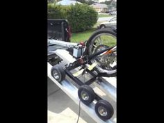 the bike is attached to the trailer on the back of the truck and has two wheels