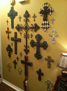 a wall with many crosses on it and a lamp in the corner next to it