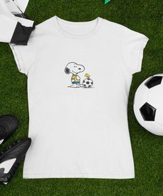 Snoopy & Woodstock Fußball T-shirt Klassisches Snoopy T-Shirt. Mit einer einfachen, aber ikonischen Snoopy-Grafik ist dieses T-Shirt perfekt für Fans der Peanuts-Serie, die einen subtilen Stil schätzen. Hergestellt aus hochwertigem, weichem Baumwollstoff, bietet dieses Hemd eine bequeme Passform für den Alltag. Egal, ob Sie zu Hause oder mit Freunden entspannen, dieses Snoopy-T-Shirt verleiht Ihrer Garderobe einen Hauch von klassischer Nostalgie und Spaß. Personalisierung verfügbar. Passende Can Peanuts T Shirts, Snoopy T Shirt, Peanuts Snoopy Woodstock, Snoopy Woodstock, Soccer Shirts, Snoopy And Woodstock, Cartoon T Shirts, Peanuts Snoopy, Woodstock