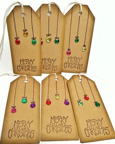 six tags with merry christmas written on them are hanging from twine strings and decorated with colored glass beads