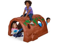 two children are sitting on a play set with a book in their hands and an adult is reading to them