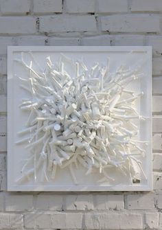 a white sculpture is mounted on a brick wall