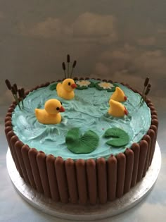 there is a cake decorated with rubber ducks in the water