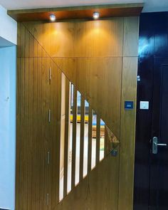 an open wooden door with mirrored glass panels on the side and below it is a hallway leading to another room