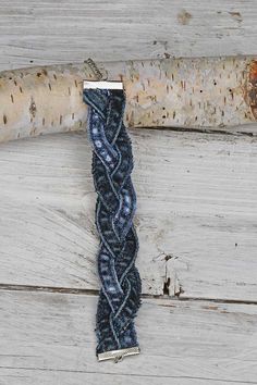 a piece of blue yarn sitting on top of a wooden table next to a tree