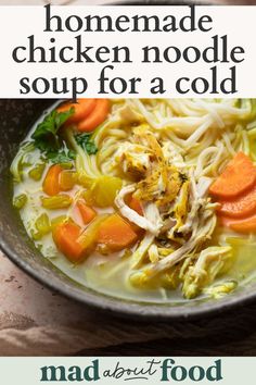 a bowl of chicken noodle soup with carrots and celery on the side