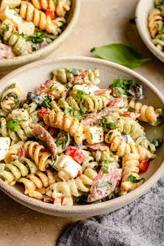 two bowls filled with pasta salad on top of a table