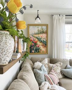 a living room filled with lots of furniture and flowers on top of the couches