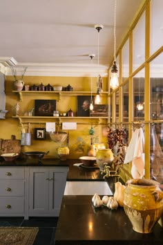 a kitchen filled with lots of counter top space and wooden shelves on the wall above it