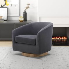 a living room with a fire place and a grey chair in front of the fireplace