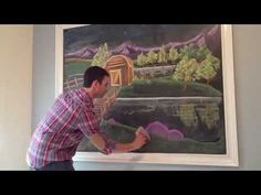 a man is painting a landscape on the wall