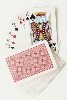 four playing cards are shown on a white surface