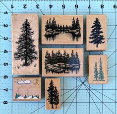 four rubber stamps with trees and mountains on them, one has a ruler in front of it