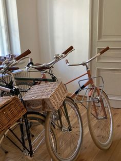 several bicycles are parked next to each other in a room with white walls and wooden floors