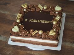 a cake with chocolate frosting and gold decorations on it that says hohenem