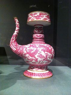 a pink and white vase sitting on top of a table