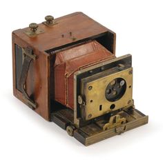 an old fashioned camera sitting on top of a wooden box