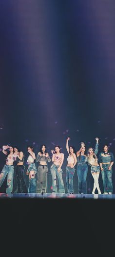 a group of people standing on top of a stage with their arms in the air