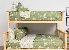 a wooden bunk bed with green and white bedspreads on it's sides