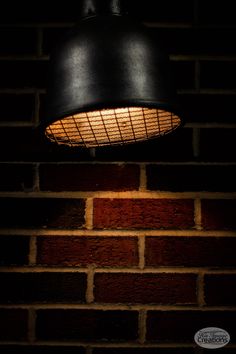 a black light hanging from the side of a brick wall