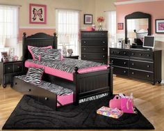 a black and pink bedroom with zebra print bedding, dressers, and mirror