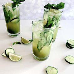 cucumber and mint mojitas are served in glasses on a white table