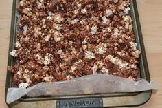 a pan filled with chocolate and marshmallows on top of a wooden table