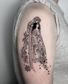 a woman with a veil and flowers tattoo on her arm