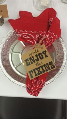 a plate with a sign that says enjoy the fixins on it, sitting on a table