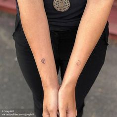 a woman holding her hands together with tattoos on them