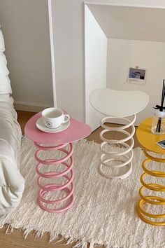 three different colored tables sitting on top of a white rug