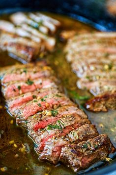 steaks are cooking in a pan on the stove