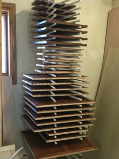 a large stack of knives sitting on top of a wooden shelf