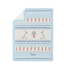 a baby blanket with rabbits and carrots on the front, in light blue colors