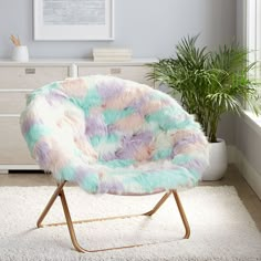 a colorful chair sitting on top of a white rug next to a potted plant