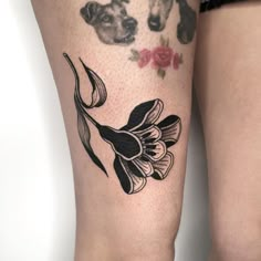 a woman's legs with flowers and dogs on them, both in black and white