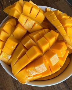 a white plate topped with sliced mangoes on top of a wooden table