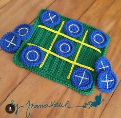 a crocheted tic - tac - toe board laying on the floor