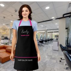 a woman wearing an apron stands in the salon