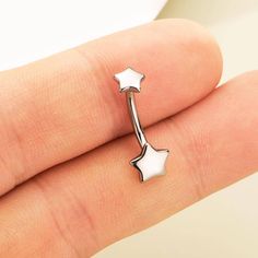 a person's finger with a star shaped nose ring on top of their finger