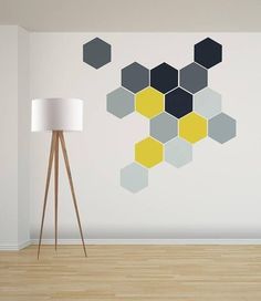 an empty room with a lamp and a wall mural on the wall that has hexagonal shapes painted on it