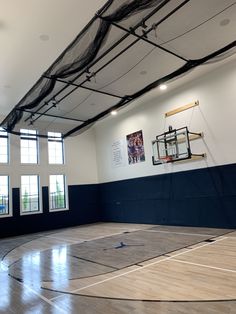 an indoor basketball court with net hanging from the ceiling