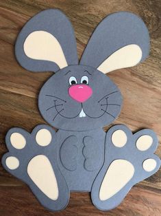 a paper cut out of a bunny sitting on top of a wooden table