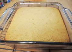 a glass baking dish filled with batter on top of a wooden table